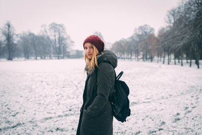 Portrait of smiling woman standing on snow