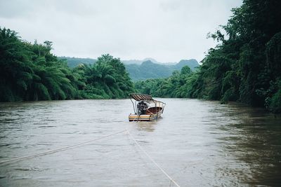 Boat sailing on river against sky