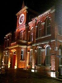 Low angle view of clock tower at night