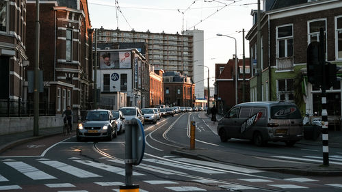 Cars on street in city against sky