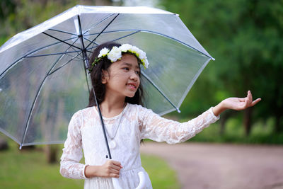 Beautiful woman standing with umbrella in rain