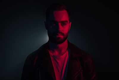 Portrait of young man against black background