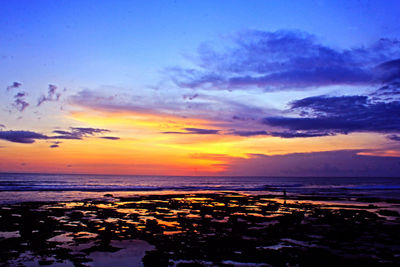 Scenic view of sea against dramatic sky during sunset