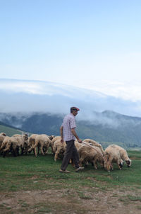 Man on field by mountains against sky