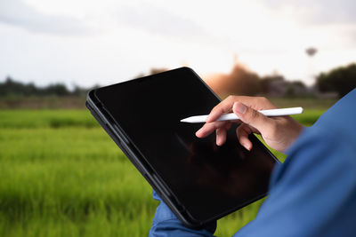 Midsection of woman using digital tablet