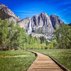 Scenic view of boardwalk with waterfall in background