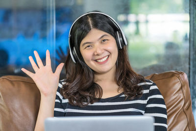 Portrait of smiling young woman using mobile phone