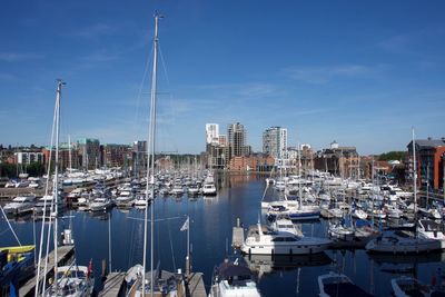 Boats moored in harbor against buildings in city