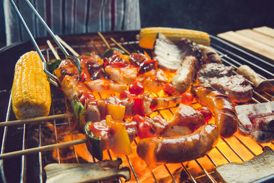 Midsection of man preparing food on barbecue grill