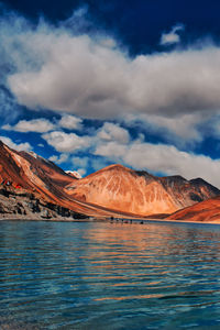 Scenic view of lake by mountains against sky