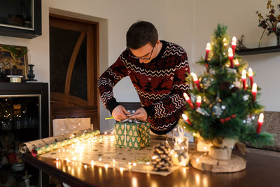 Young man packs christmas presents for friends and family