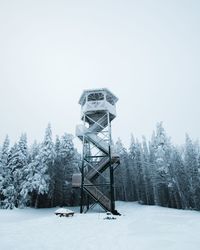 Built structure on snow covered field against sky