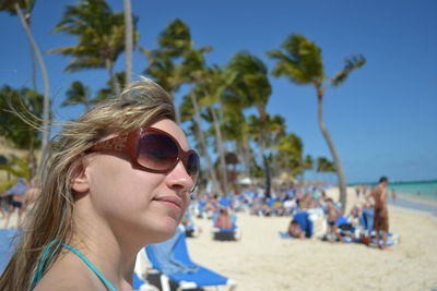 Portrait of man wearing sunglasses at beach against sky