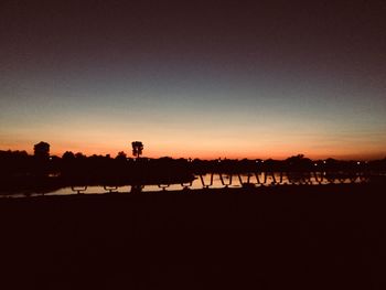 Silhouette landscape against clear sky during sunset