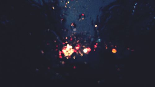 Defocused image of illuminated lights in city at night