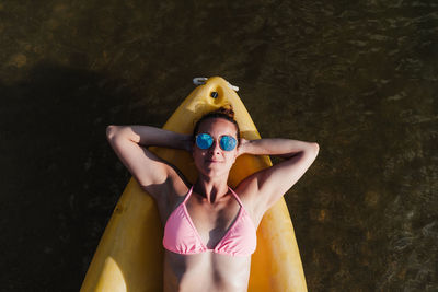 High angle view of woman lying down on canoe