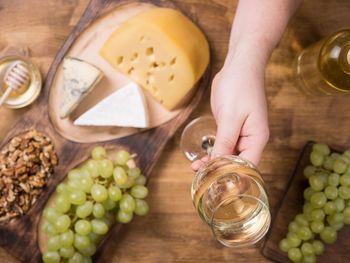 Cropped hand of woman holding food on table