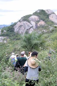 Rear view of people walking on mountain