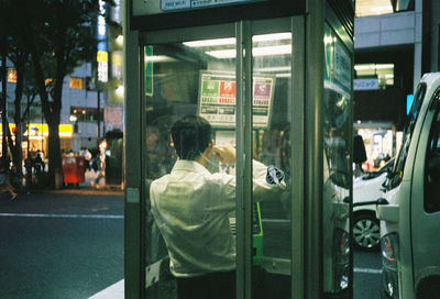 Rear view of man standing on train window