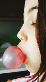 Close-up of girl blowing bubble gum