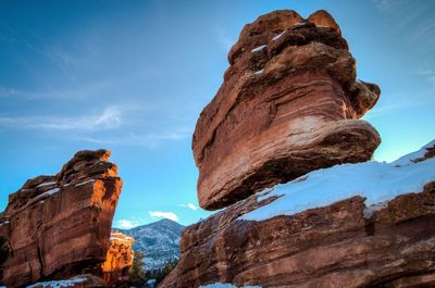 Low angle view of rock formations against sky during winter