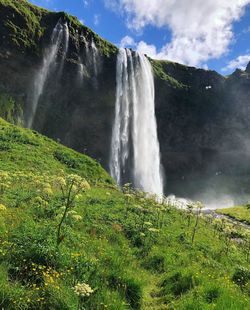 Scenic view of waterfall against sky