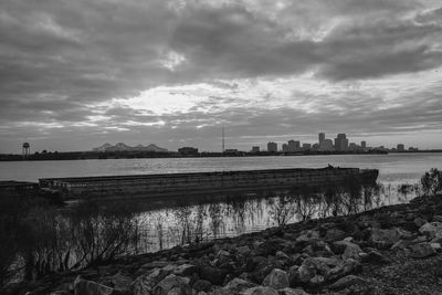 Scenic view of river against cloudy sky