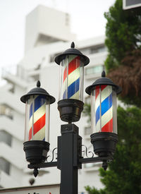 Tricolored sign in front of a japanese barbershop
