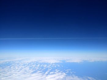 Aerial view of clouds over sea against blue sky