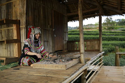 Woman sitting on wooden structure