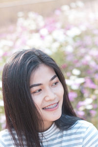 Close-up of young woman smiling at park