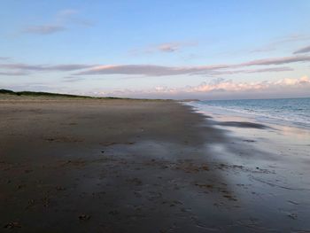 Scenic view of beach against sky during sunset