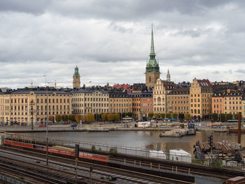 View of buildings in city against cloudy sky