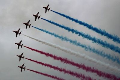 Low angle view of airshow against sky