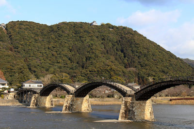 Arch bridge over river against sky