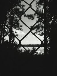 Silhouette fence against sky at dusk