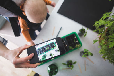 High angle view of man using smart phone on table