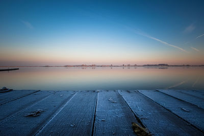 Scenic view of lake against sky at sunset