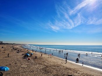 People on beach against blue sky