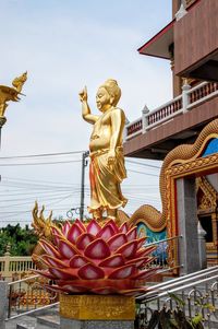 Statue against temple building against sky