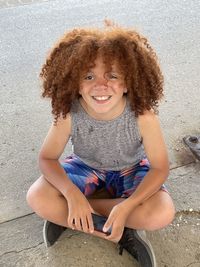 Portrait of young boy sitting on floor