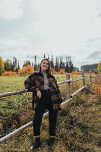 Portrait of young woman standing on land against sky