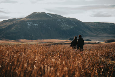 Rear view of woman walking on field