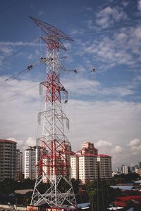 Low angle view of cranes against buildings in city