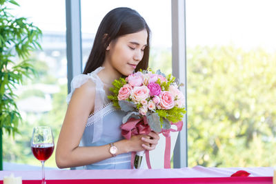 Beautiful woman sitting on table by window