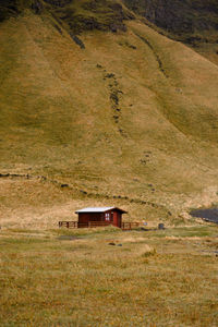 House on field against mountain