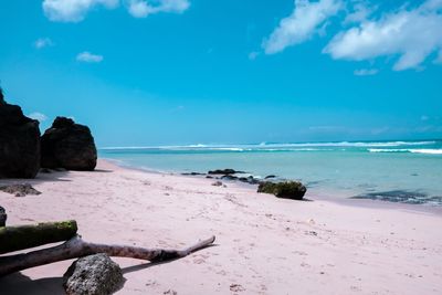 Rocks on beach against blue sky