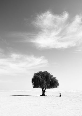 Woman walking on dessert against sky