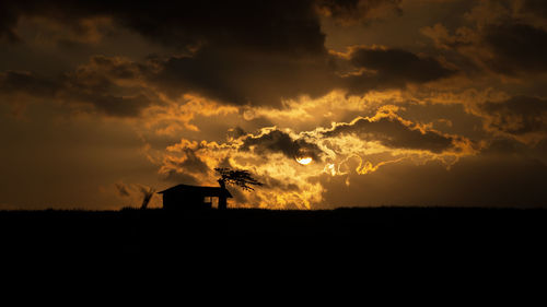 Scenic view of silhouette field against sky during sunset