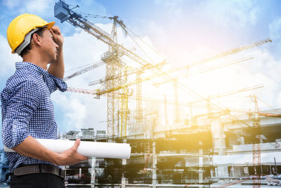 Side view of architect standing against construction site